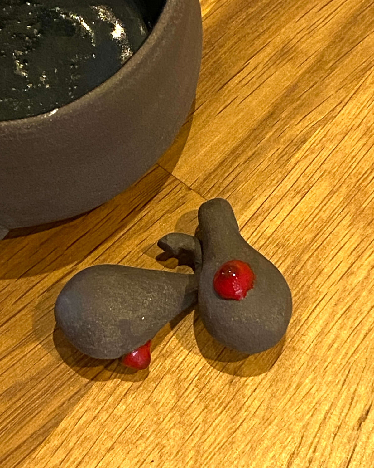 Ullas aftagelige detaljer i sort ler med røde prikker ved siden af potten