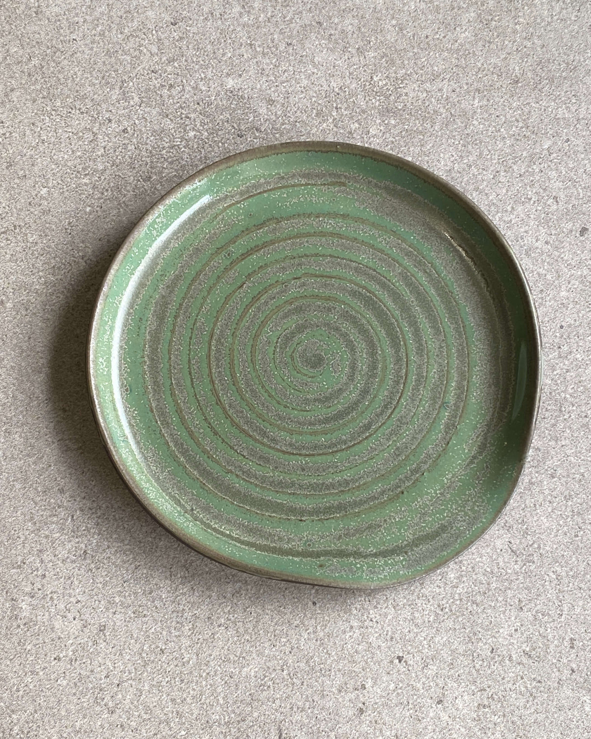 Rund grydeskeholder Green Spiral i grøn glasur med drejet spiral – håndlavet keramik fra Keramikbyh
